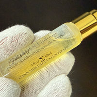 Cannabis perfume extract strain Gelato 41 bottle held by a gloved hand against a dark background