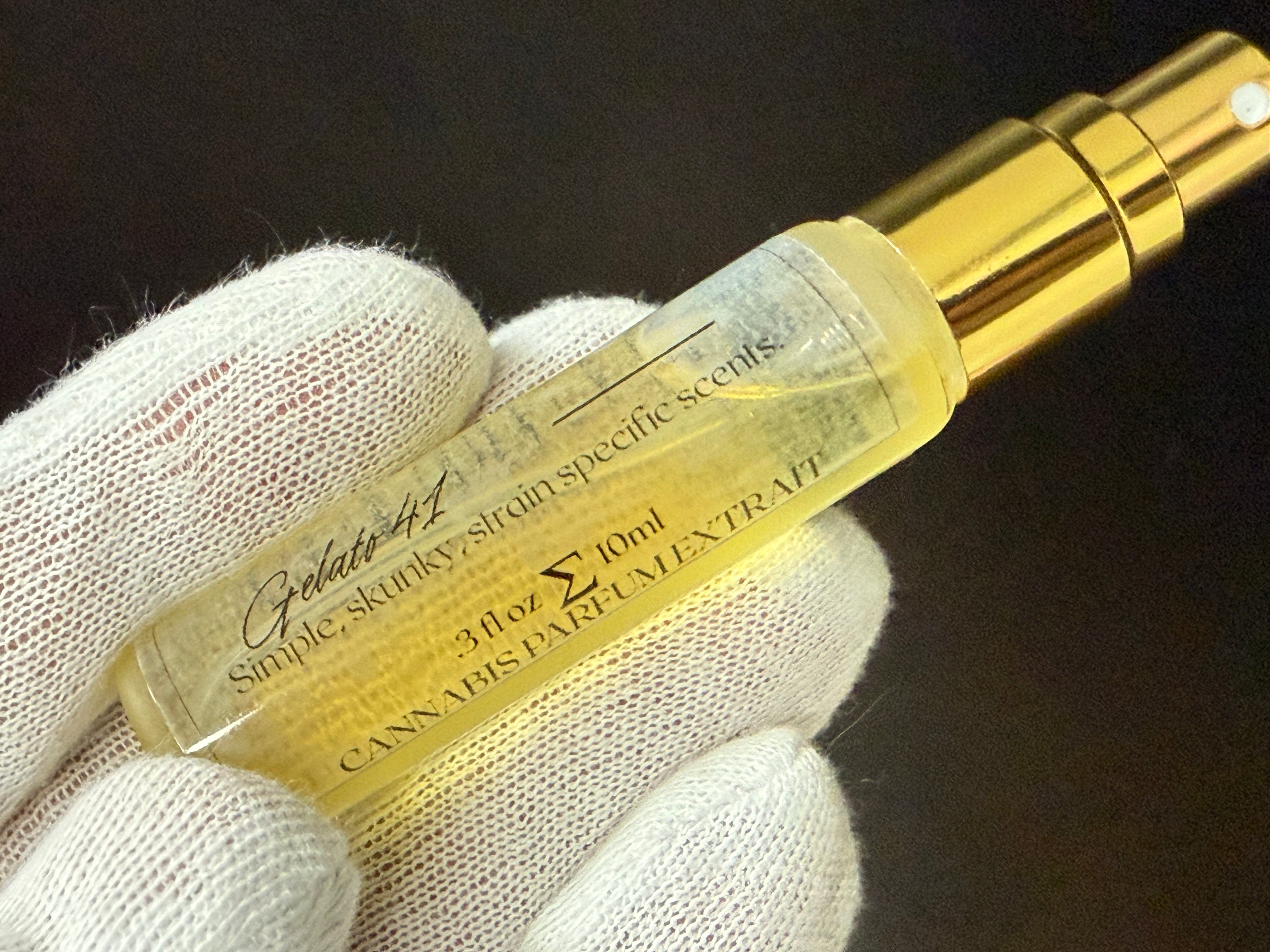 Cannabis perfume extract strain Gelato 41 bottle held by a gloved hand against a dark background