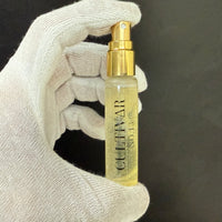 Hand holding a Cultivar No. 13 spray bottle against a dark background